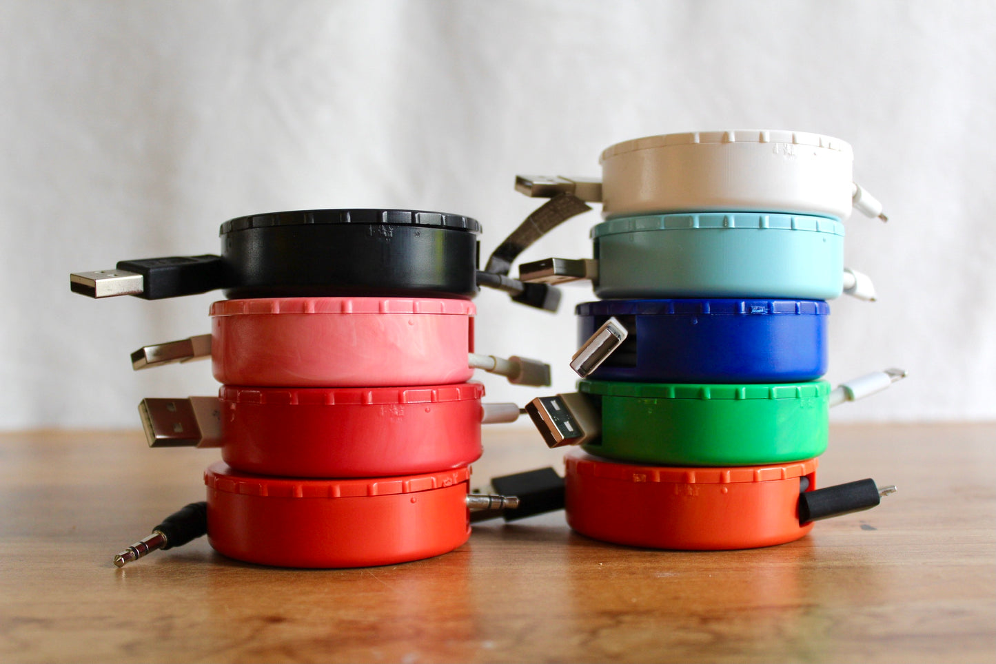 Display of all of the colors CordPuck cord organizer come in to store cords and chargers