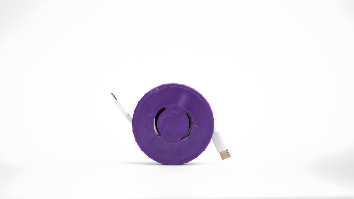 Purple Cordpuck cord organizer storing and protecting a Apple Lightning Charger Cable