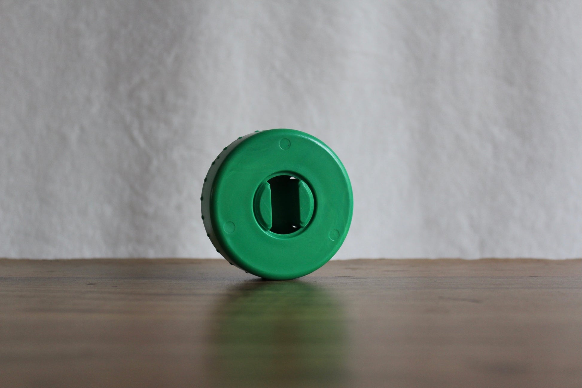 Green-colored CordPuck cord organizer